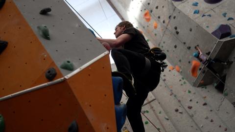 Side on photo of a paraclimber mid climb. 