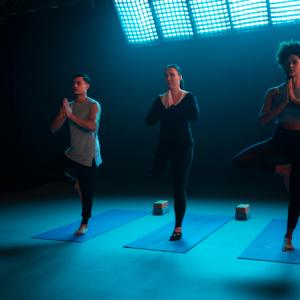 A man and two women with physical impairments doing yoga
