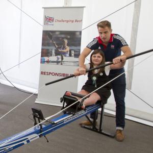 A girl tries canoe on an indoor simulator machine