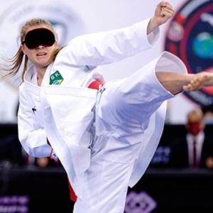 A girl with a blindfold on practicing Karate